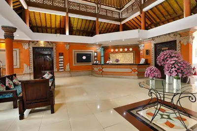 a large lobby with a glass table and flowers at Puri Saron Hotel Seminyak in Seminyak