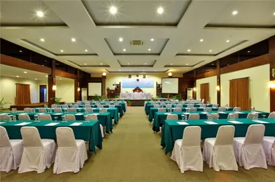 a large banquet hall with blue tables and white chairs at Puri Saron Hotel Seminyak in Seminyak