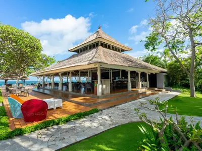 a pavilion on the beach with chairs and the ocean at Discovery Kartika Plaza Hotel in Kuta