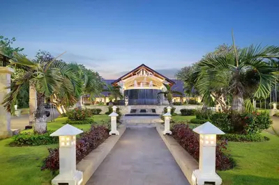 a house with a pathway in front of a building at Discovery Kartika Plaza Hotel in Kuta