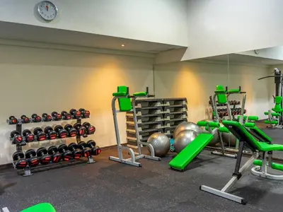 a gym with dumbbells and weights in a room at Discovery Kartika Plaza Hotel in Kuta