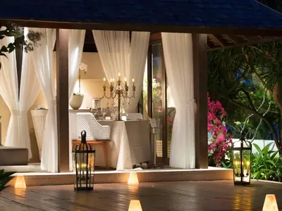 a dining room with white curtains and a table at The Royal Santrian in Nusa Dua