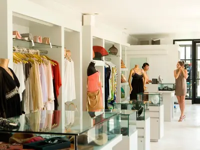 a woman standing in a clothing store with a display case at The Royal Santrian in Nusa Dua