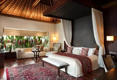 a bedroom with a large bed and a living room at The Royal Santrian in Nusa Dua