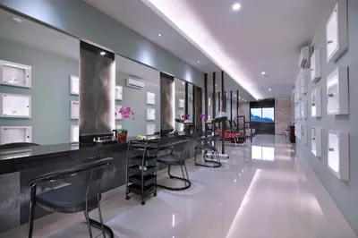 a bar in a room with stools and tables at Famous Hotel Kuta Formerly Permata Kuta Hotel in Kuta