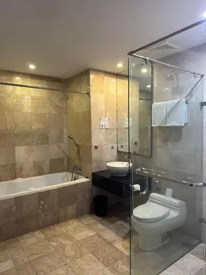 a bathroom with a toilet and a tub and a sink at Famous Hotel Kuta Formerly Permata Kuta Hotel in Kuta