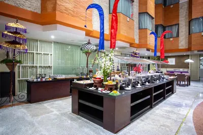 a restaurant with a counter with food on it at Famous Hotel Kuta Formerly Permata Kuta Hotel in Kuta