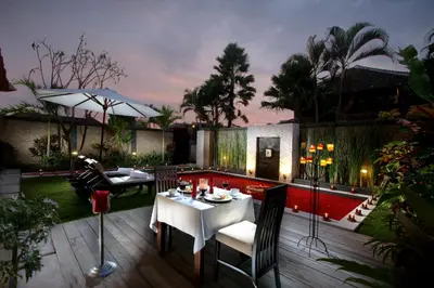 a patio with a white table and chairs on a deck at Bali Rich Villas in Seminyak