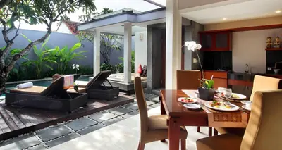 a dining room and living room with a table and chairs at Aria Exclusive Villas & SPA in Seminyak
