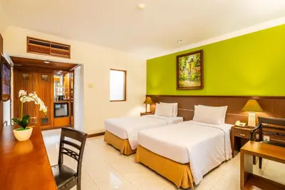 two beds in a room with a green wall at Risata Bali Resort & Spa in Kuta