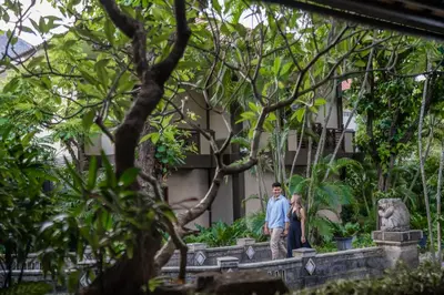 a man and a woman standing in front of a building at Risata Bali Resort & Spa in Kuta