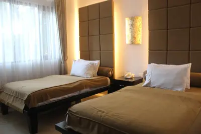 a hotel room with two beds and a window at The Radiant Hotel in Kuta