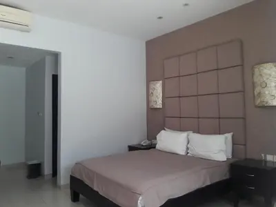 a bedroom with a large bed with white pillows at The Radiant Hotel in Kuta