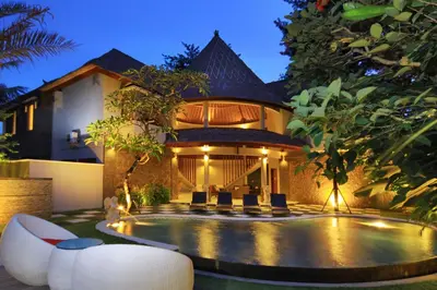 a villa with a swimming pool in front of a building at Abi Bali Resort and Villa in Jimbaran
