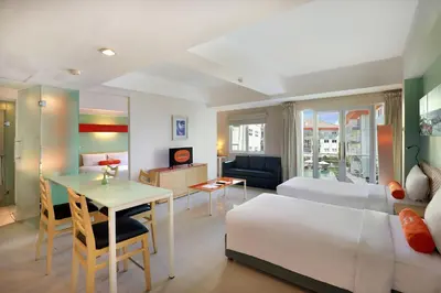 a hotel room with a bed and a table and a desk at HARRIS Hotel & Residences Riverview Kuta, Bali in Kuta