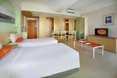 a hotel room with two beds and a table at HARRIS Hotel & Residences Riverview Kuta, Bali in Kuta