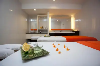 a hotel room with two beds and a tray of food on a table at HARRIS Hotel & Residences Riverview Kuta, Bali in Kuta