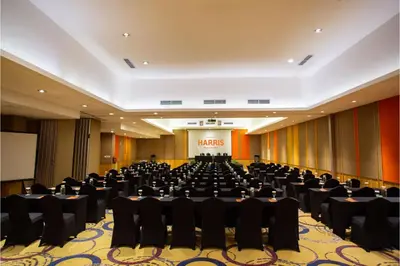 a large conference room with chairs and a podium at HARRIS Hotel & Residences Riverview Kuta, Bali in Kuta