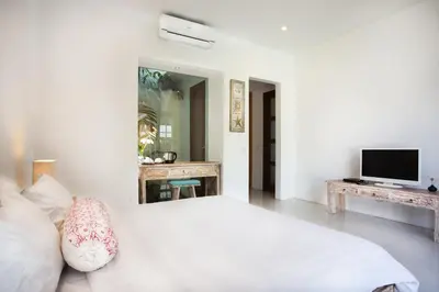 a living room with a white couch and a television at Villa Kim Seminyak in Seminyak