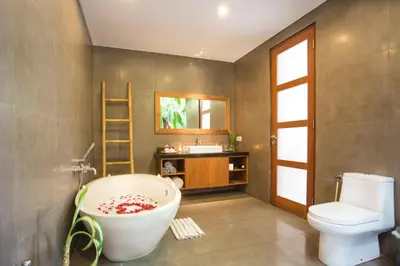 a bathroom with a tub and a toilet and a sink at Villa Kim Seminyak in Seminyak