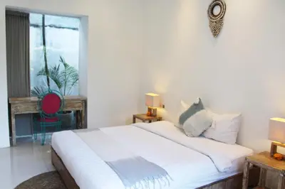 a bedroom with a large white bed and a window at Villa Kim Seminyak in Seminyak