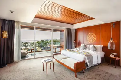 a bedroom with a large bed and a large window at Jimbaran Bay Beach Resort and Spa by Prabhu in Jimbaran