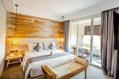 a bedroom with a large white bed and a couch at Jimbaran Bay Beach Resort and Spa by Prabhu in Jimbaran