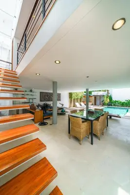 an open living room with stairs and a table at Villa Rio - Contemporary 2BR Villa in Downtown Seminyak in Seminyak