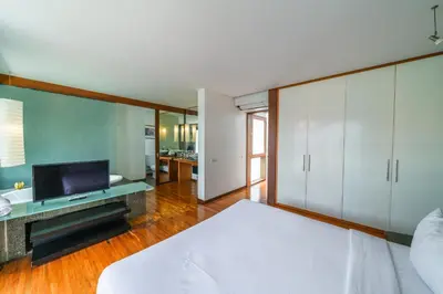 a bedroom with a white bed and a television at Villa Rio - Contemporary 2BR Villa in Downtown Seminyak in Seminyak