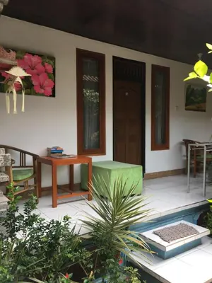 a porch of a house with a table and chairs at Nadialit in Seminyak