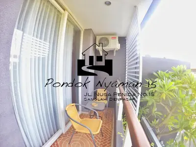a balcony of a condo with a yellow chair at Pondok Nyaman 15 in Denpasar