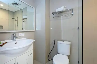 a bathroom with a sink and a toilet and a mirror at Pondok Nyaman 15 in Denpasar