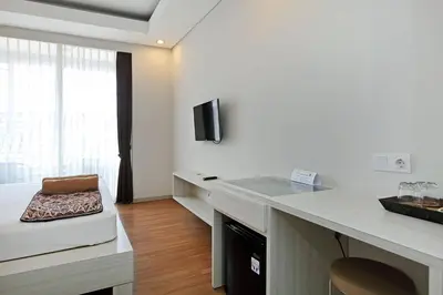 a white room with a desk with a chair at Pondok Nyaman 15 in Denpasar