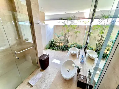 a bathroom with two sinks and a toilet and a shower at Villa Meliya in Canggu