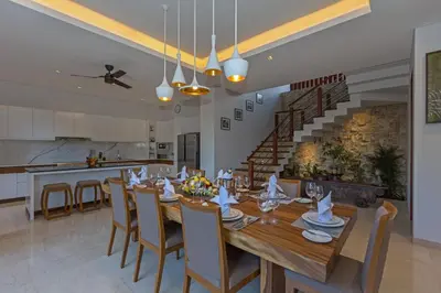 a dining room with a large wooden table and chairs at Villa Meliya in Canggu