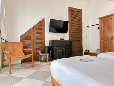 a bedroom with a bed and a tv and a chair at Villa Soleh in Seminyak