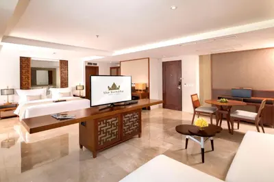 a hotel room with a bed and a living room at The Bandha Hotel & Suites in Legian