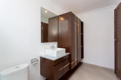 a bathroom with a sink and a toilet and a mirror at Paisa Villa Seminyak in Seminyak