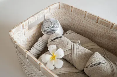 a basket with towels and a flower in it at Villa Taramille by Villa Finder in Kerobokan