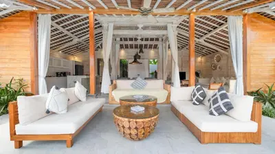 a patio with white couches and a coffee table at Villa Taramille by Villa Finder in Kerobokan