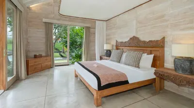 a bedroom with a large bed and a large window at Villa Alea by Villa Finder in Kerobokan
