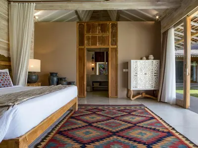 a bedroom with a bed and a rug at Villa Mannao by Villa Finder in Kerobokan
