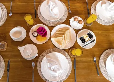 a wooden table with plates of food on it at Villa Little Mannao by Villa Finder in Kerobokan