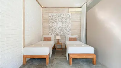 two beds in a room with white walls at Villa Little Mannao by Villa Finder in Kerobokan