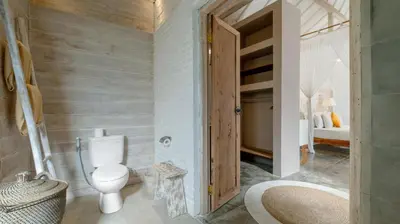 a bathroom with a toilet and a sink at Villa Little Mannao by Villa Finder in Kerobokan