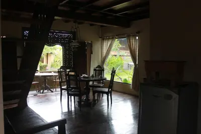 a dining room with a table and chairs and a window at Puri Kutat Lestari in Sanur