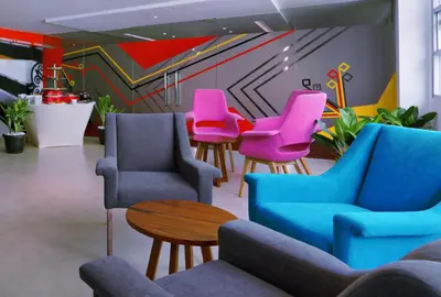 a waiting room with colorful chairs and a table at favehotel Kuta Kartika Plaza in Kuta