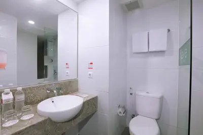 a white bathroom with a sink and a toilet at favehotel Kuta Kartika Plaza in Kuta