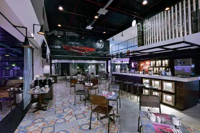 a restaurant with tables and chairs and a bar at favehotel Kuta Kartika Plaza in Kuta
