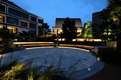 a courtyard in a building at night with a building at Golden Tulip Jineng Resort Bali in Kuta